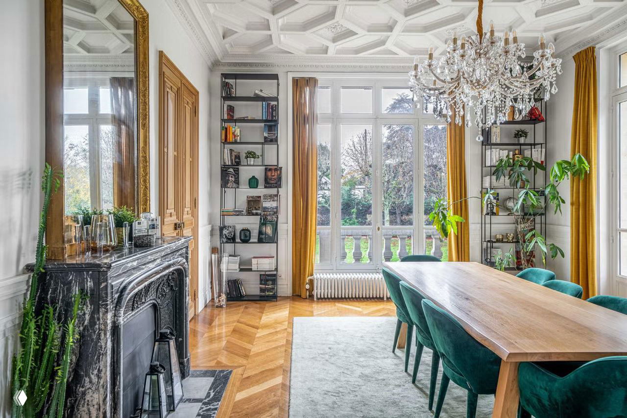 Роскошная столовая особняка с мраморным камином, большими окнами в пол и хрустальной люстрой — классический интерьер начала XX века.