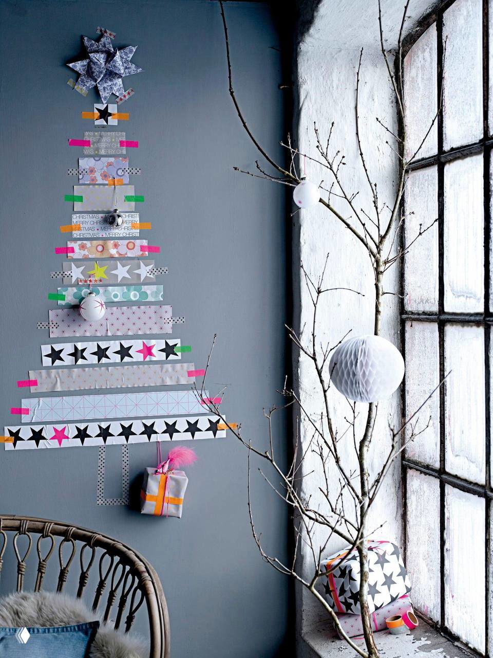 Декоративная «ленточная» елка на стене из разноцветных скотч-ленточек и ветка в вазе у большого окна — минималистичный праздничный акцент без ели.