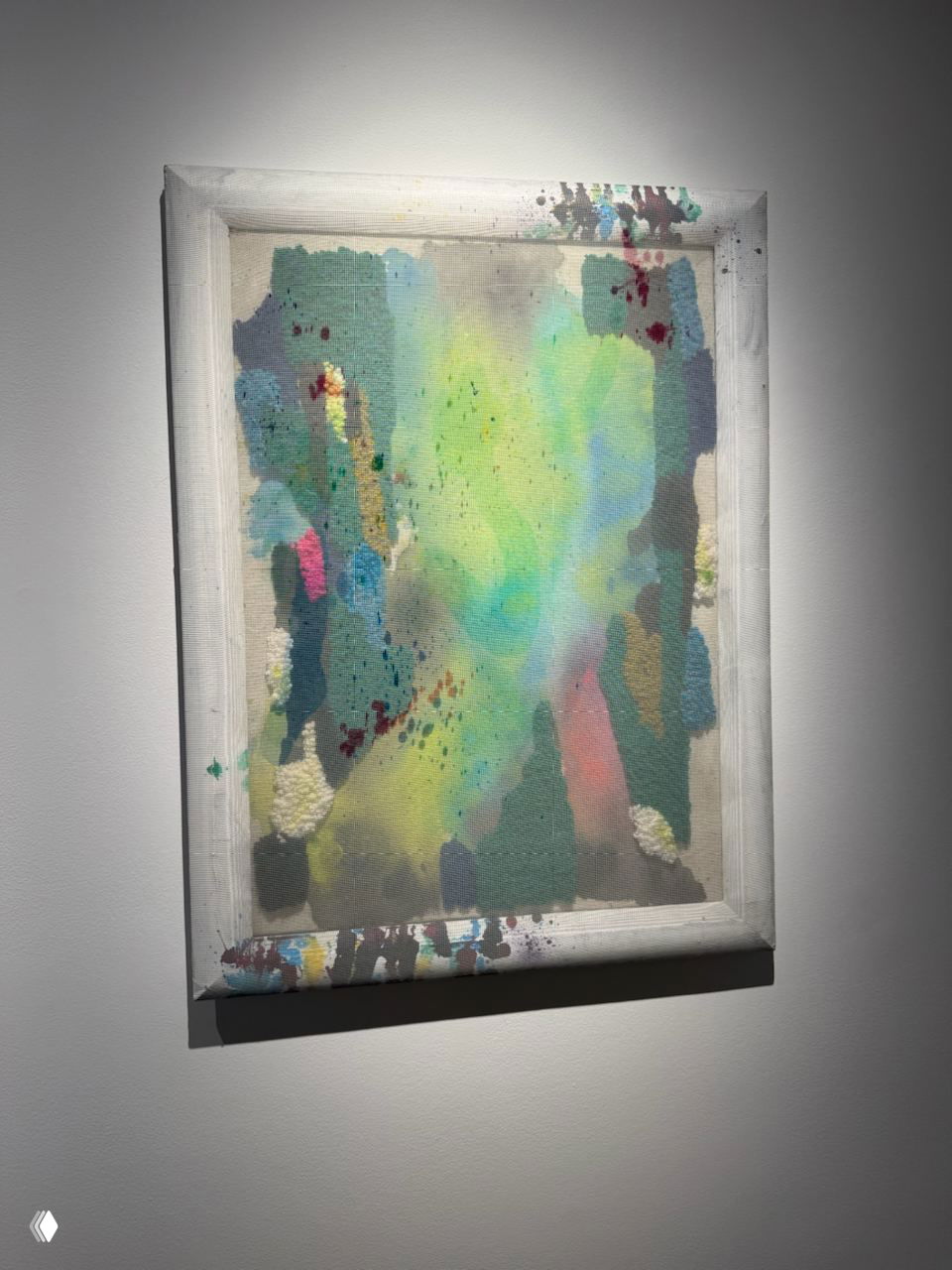 Абстрактная живопись с мягкими пастельными переходами в белой раме, инсталляция на стене галереи под направленным светом.