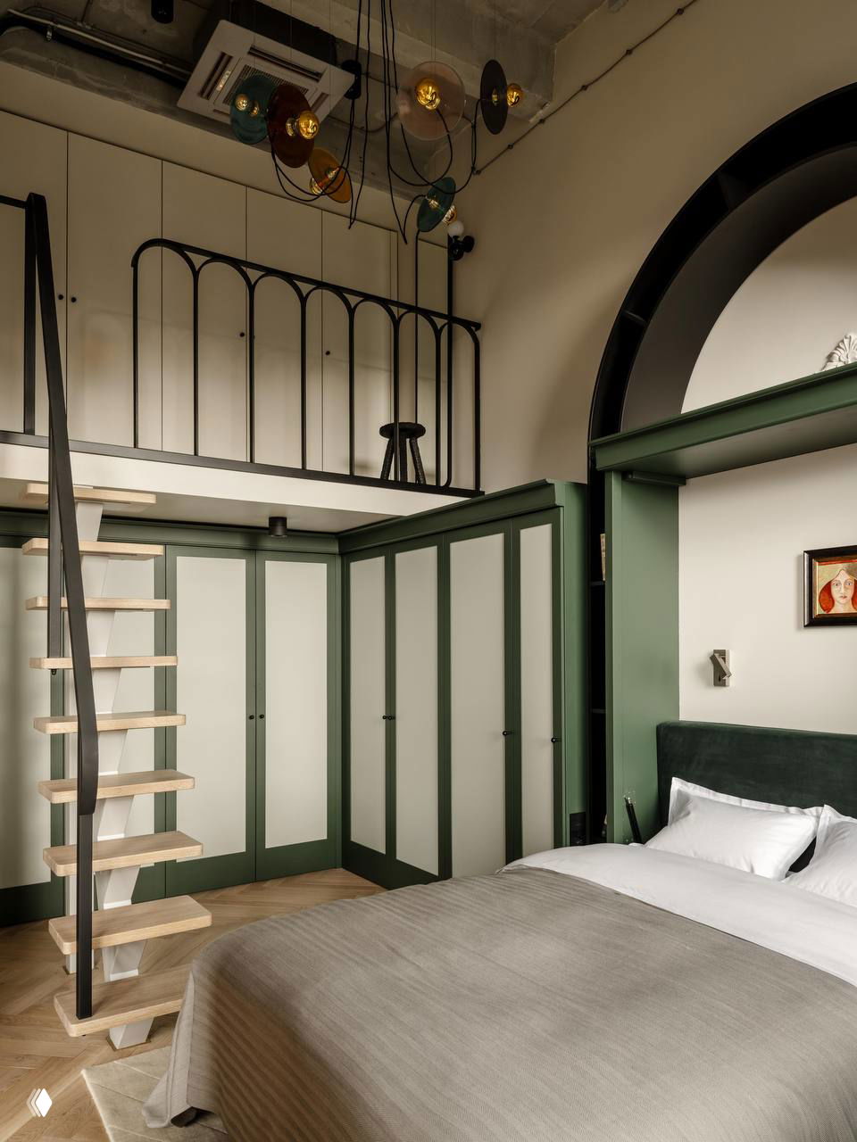 Высокие шкафы с зелёными рамами и светлыми дверцами в комнате с антресолью и деревянной лестницей, интерьер с лофтовыми нотами.