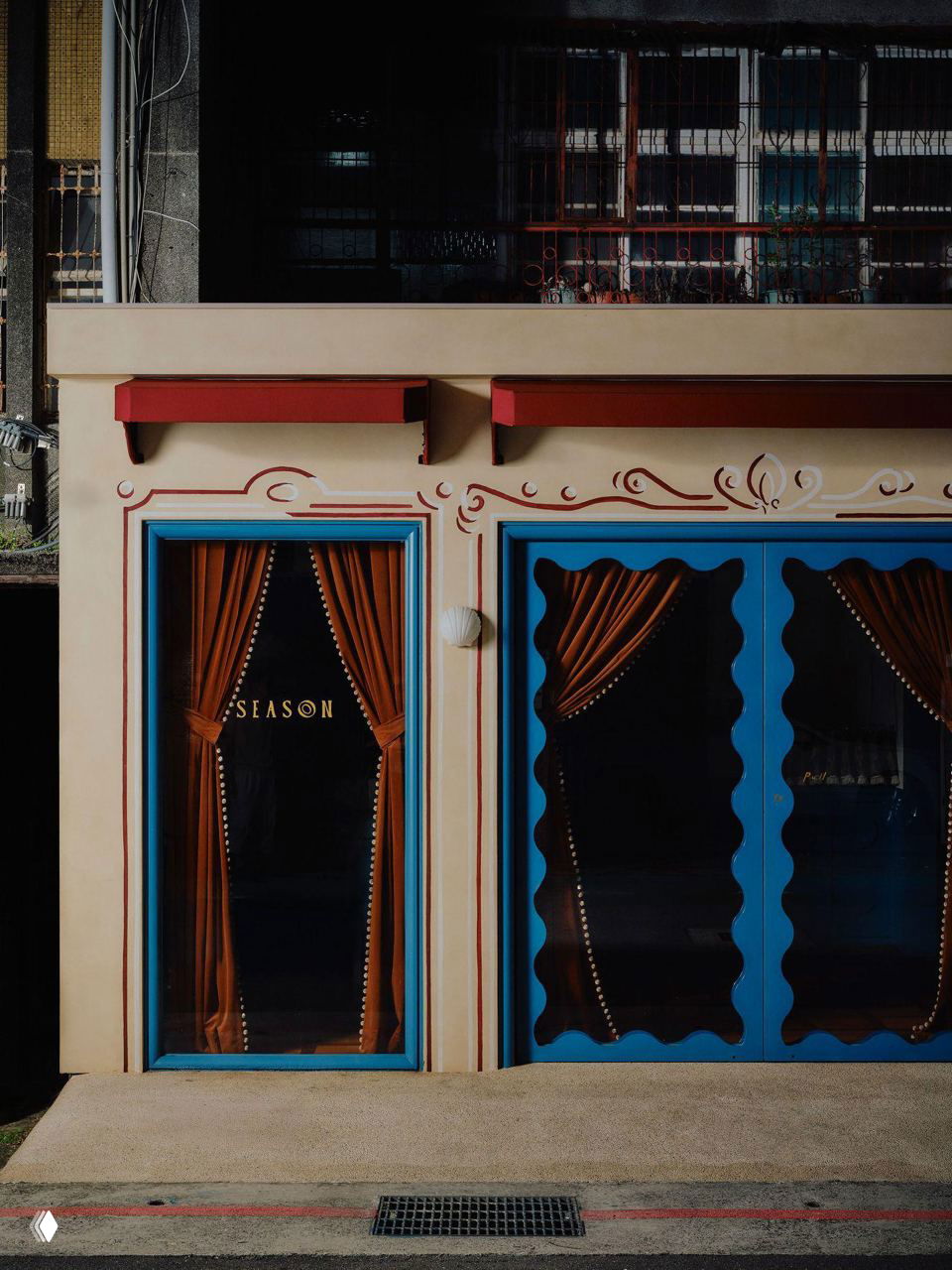 Фасад кондитерской Season в Тайбэе: пастельная штукатурка, яркие синие рамки окон и бархатные коричневые занавеси за витриной.