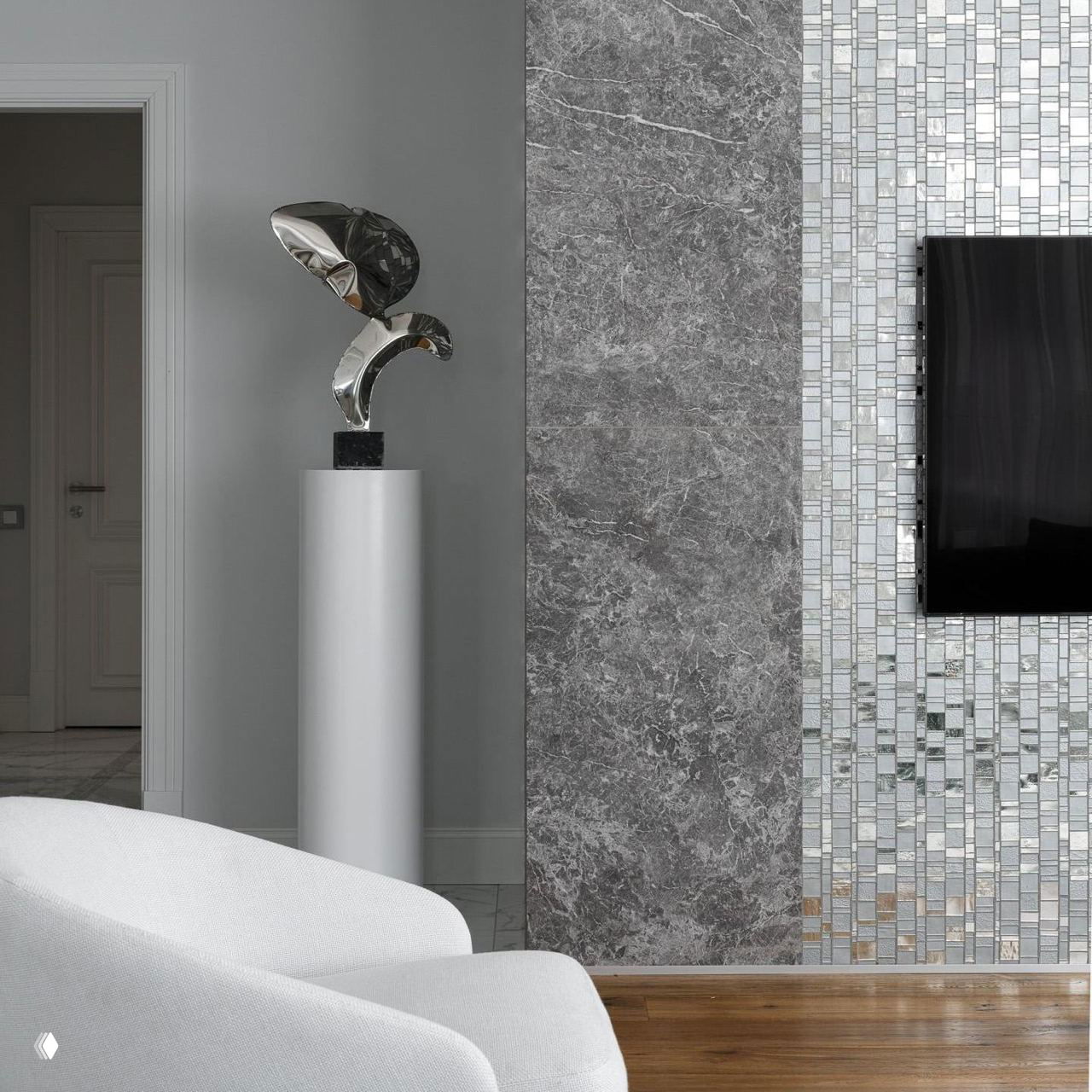 Современный интерьер с серебристой скульптурой, мраморной плиткой и белыми креслами — акцент на металле.