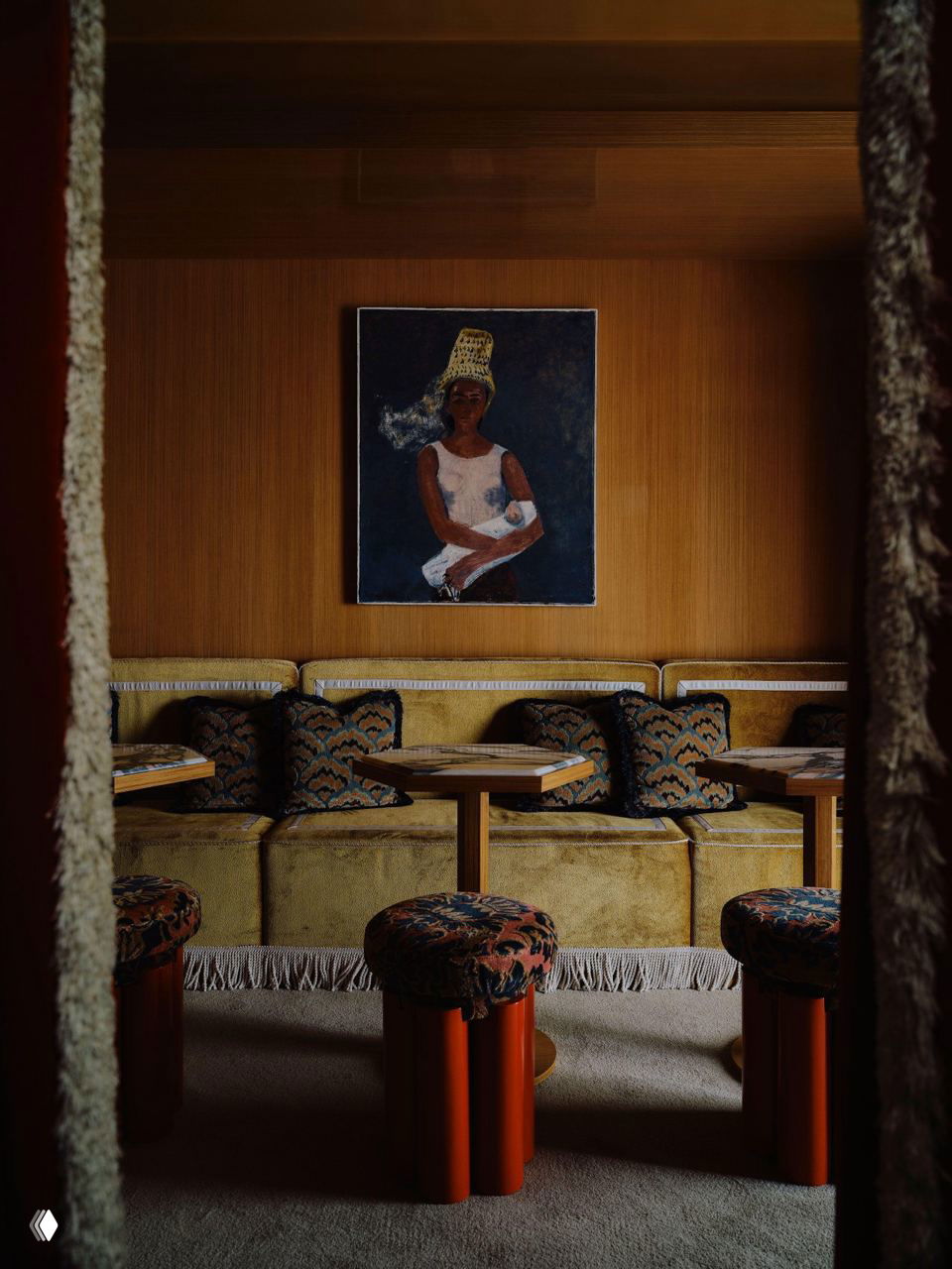 Ряд барных стульев на фоне тяжёлых портьер: фактурная обивка, приглушённое освещение и плотные занавеси, создающие интимную атмосферу.