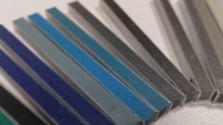 Фотография веерной палитры выкрасов для плиточной затирки PLITONIT с образцами разных синих, серых и нейтральных оттенков вблизи.