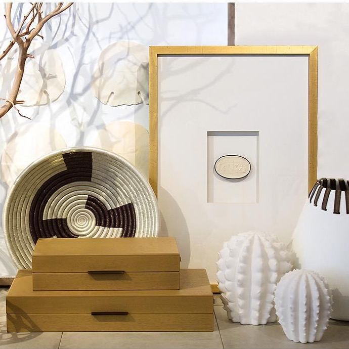 Декоративная композиция: плетёная корзина, рамка и фигурные свечи на светлой полке — акцент на текстуры и стиль в интерьере