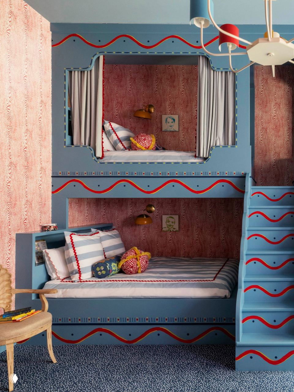 Детская комната с двухъярусными кроватями, выкрашенными в голубой цвет, лестница-горка, красочные текстильные акценты и большой оконный проём с видом на зелень.