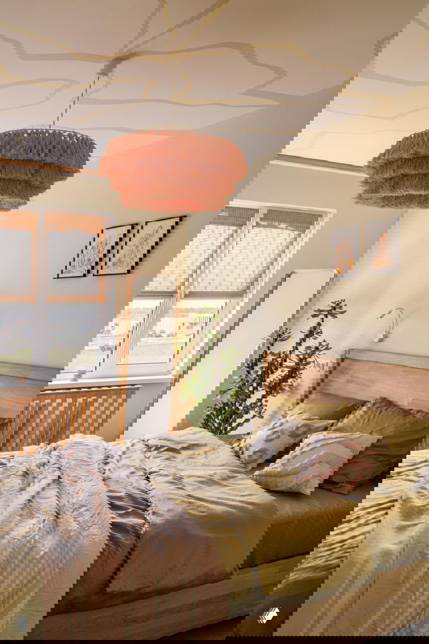 Ещё один ракурс гостиной: розовый диван, жёлтый столик и зеркальный диско‑шар на ковре, рядом зелёные растения и подсвеченные ниши в шкафах создают живой образ интерьера.