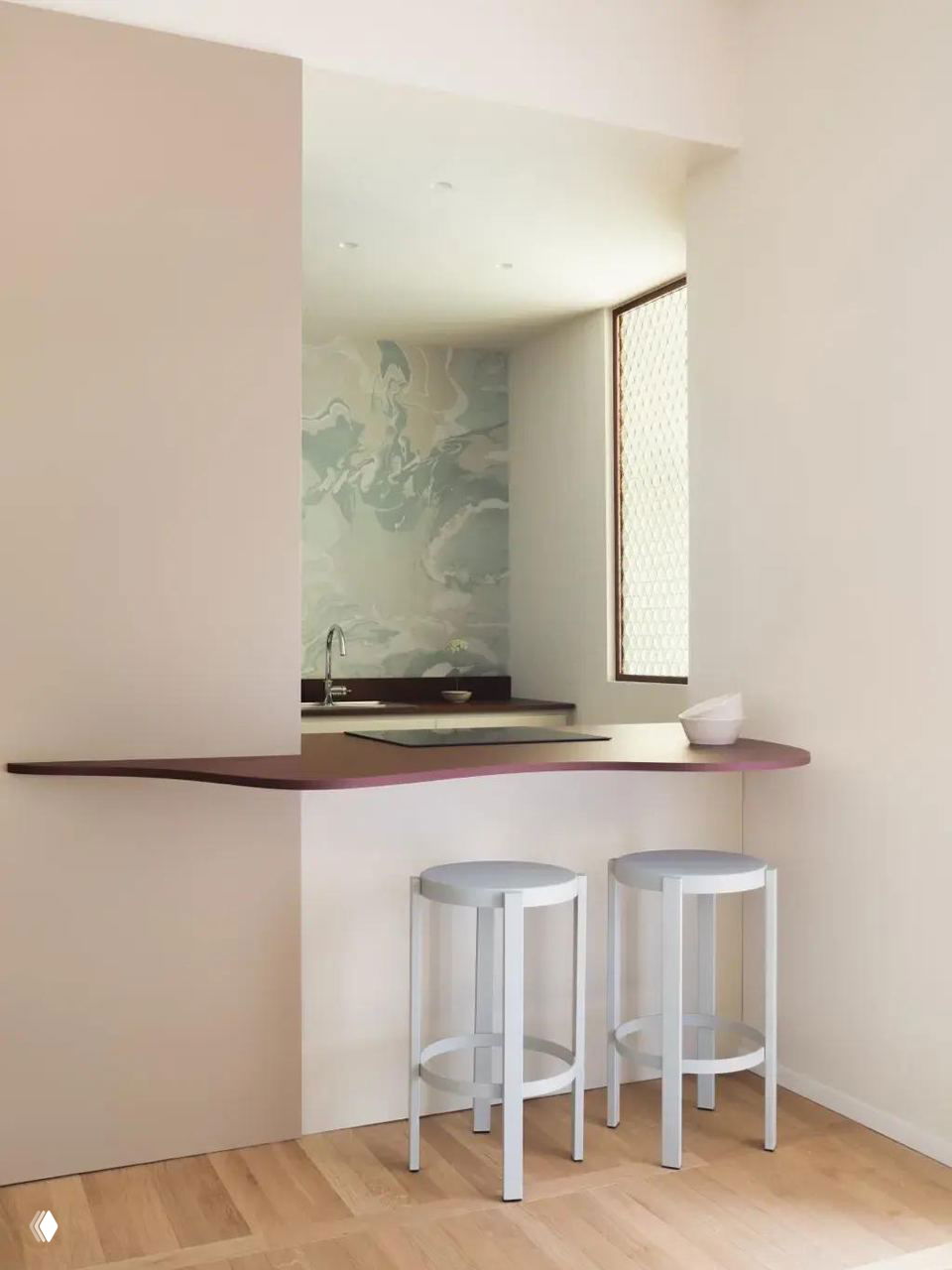 Минималистичная проходная кухонная ниша с барной столешницей и двумя светлыми табуретами — пример окна‑проёма между зонами