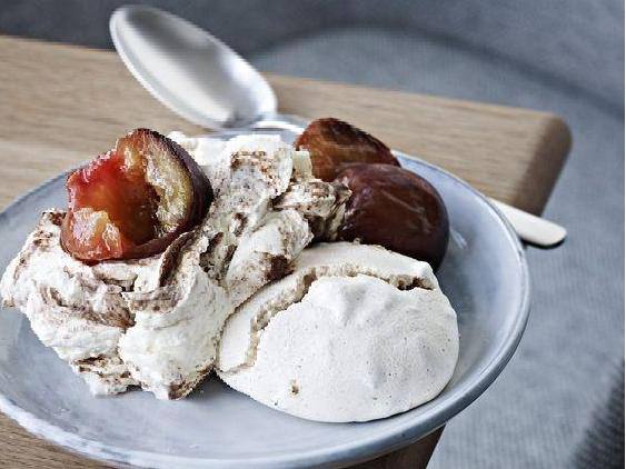 Порция орехового безе с карамелизированными финиками и ложкой рядом, пастельная сервировка в миске для десерта.