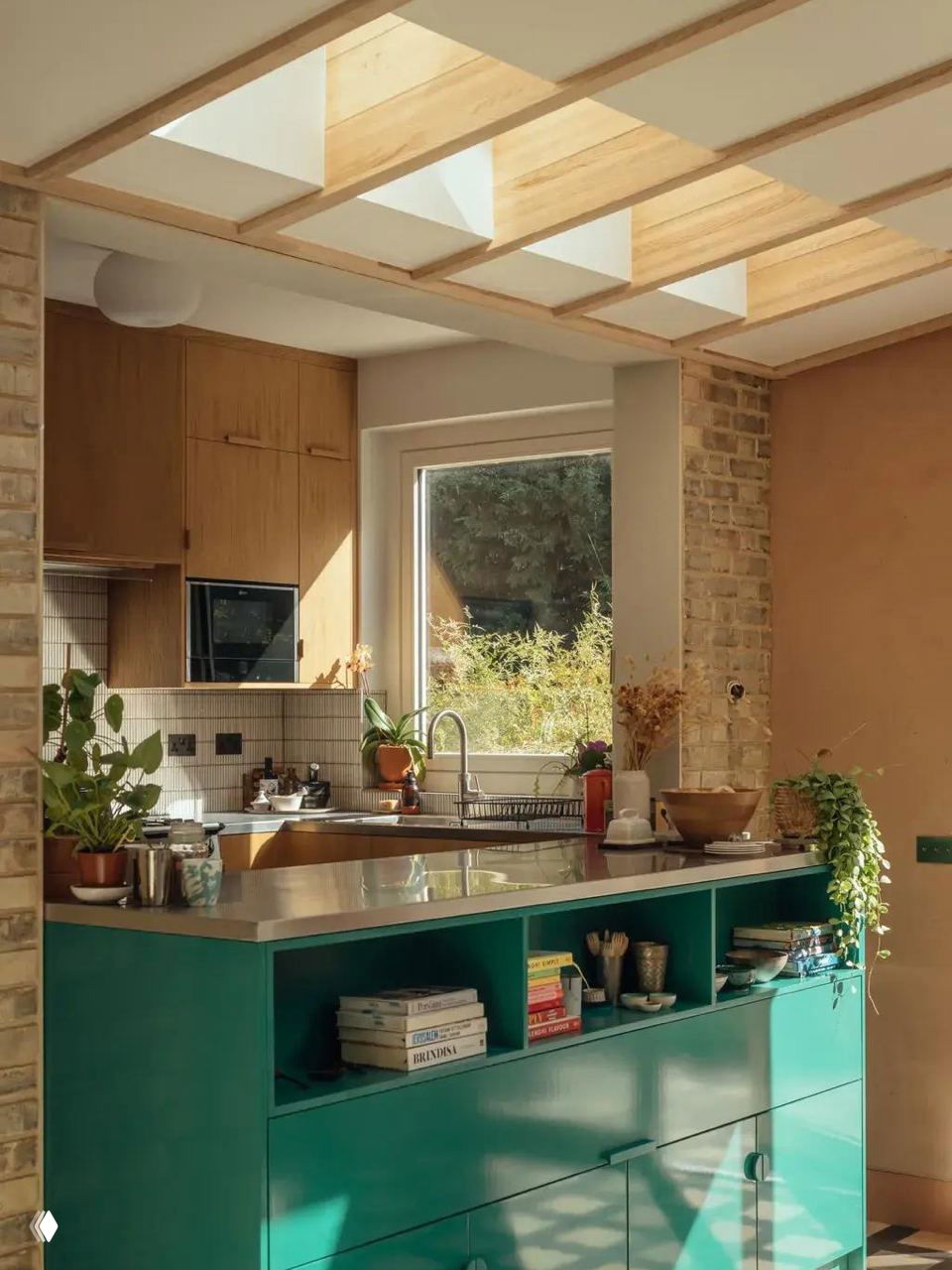 Гофрированное матовое стекло в рамке на фоне бордовой облицовки — пример частично закрытого оконного проёма между кухонными зонами