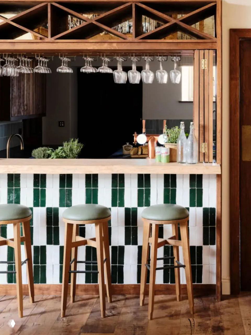 Кухонный остров яркого зелёного цвета с открытыми полками, большое окно над мойкой и деревянные балки на потолке — тёплый интерьер с проёмом