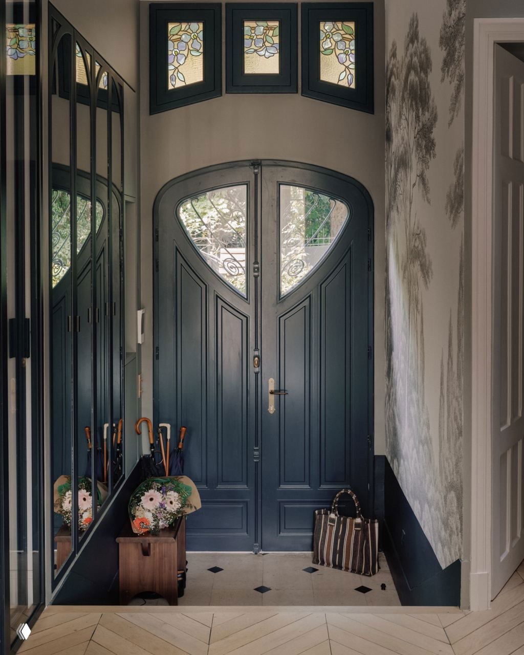 Прихожая с новой дверью, в которую интегрированы отреставрированные витражи: тёмная деревянная дверь и витражные вставки над ней.
