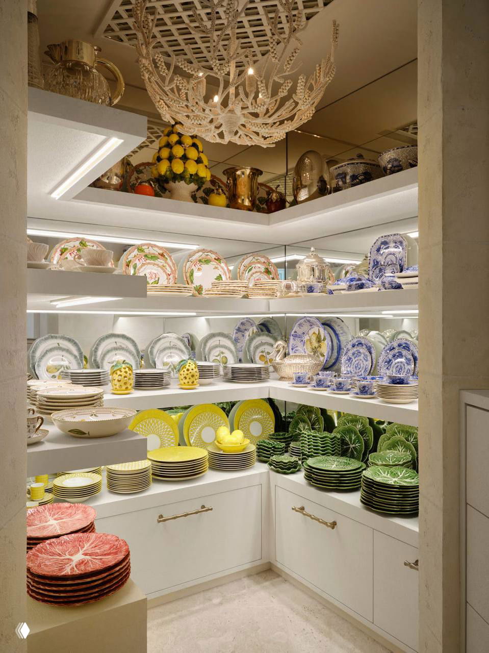 Открытая витрина с сервировочной посудой: полки с расписными тарелками и декоративными элементами, подсвеченные в нише кладовой или буфета.