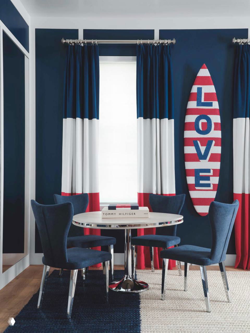 Столовая или игравая зона в сине‑белой гамме с серфбордом «LOVE», хромированным столом и стульями — смелый акцент в общем интерьере дома.