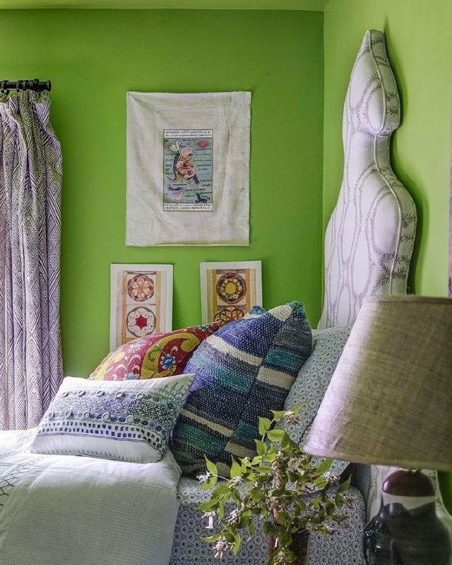 Классическая маленькая спальня с цветной текстильной накидкой и растениями у изголовья — тёплый камерный интерьер со шторами и мягкими аксессуарами.