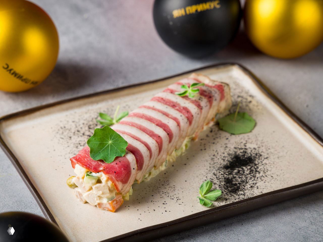 Авторская подача салата оливье в форме рулета, слой с уткой сверху, зелень и праздничная сервировка на тарелке