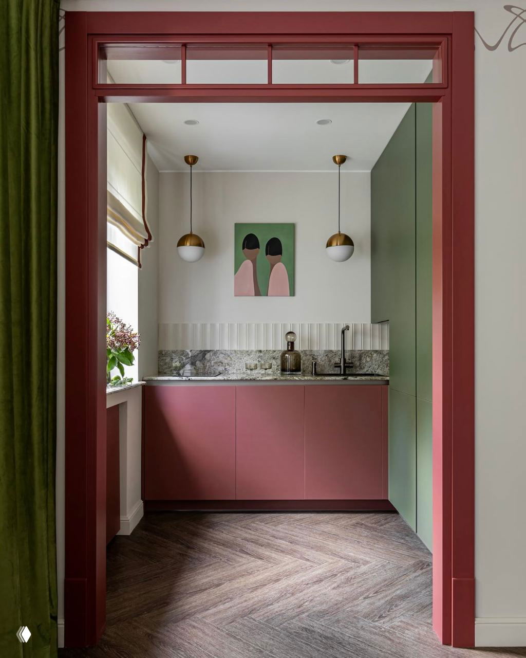 Узкая кухня в пастельных тонах с розово‑зелёными фасадами, мраморной столешницей и симметрично висящими плафонами над рабочей зоной.