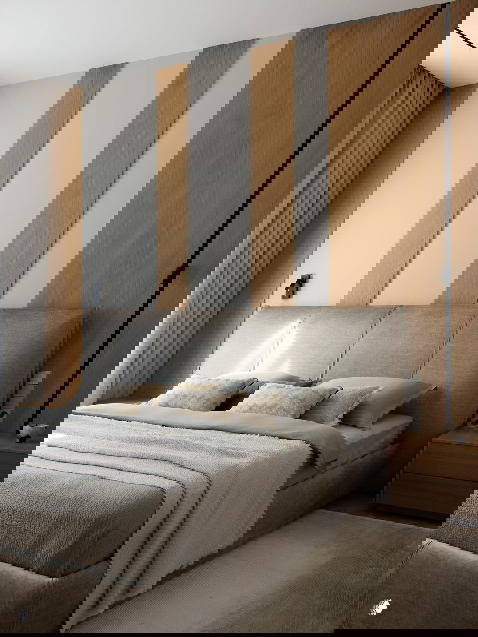 Спальня с мягким изголовьем и бежево‑серым текстилем, вертикальные деревянные панели за кроватью и прикроватные тумбы в сканди‑стиле.