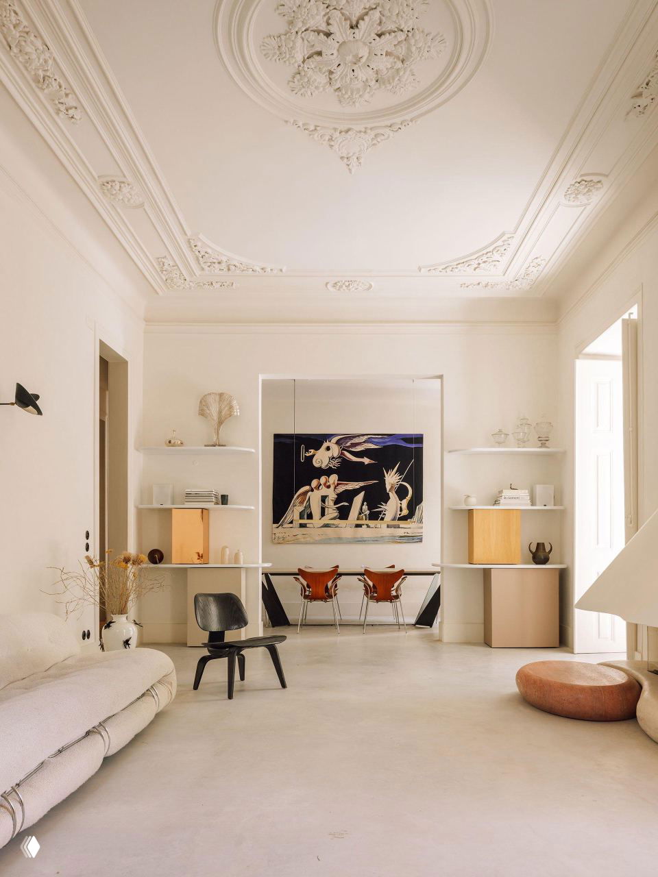 Интерьер в светло‑молочном оттенке Cloud Dancer: высокая лепнина на потолке, минималистичная мебель, картина на стене и мягкий дневной свет.