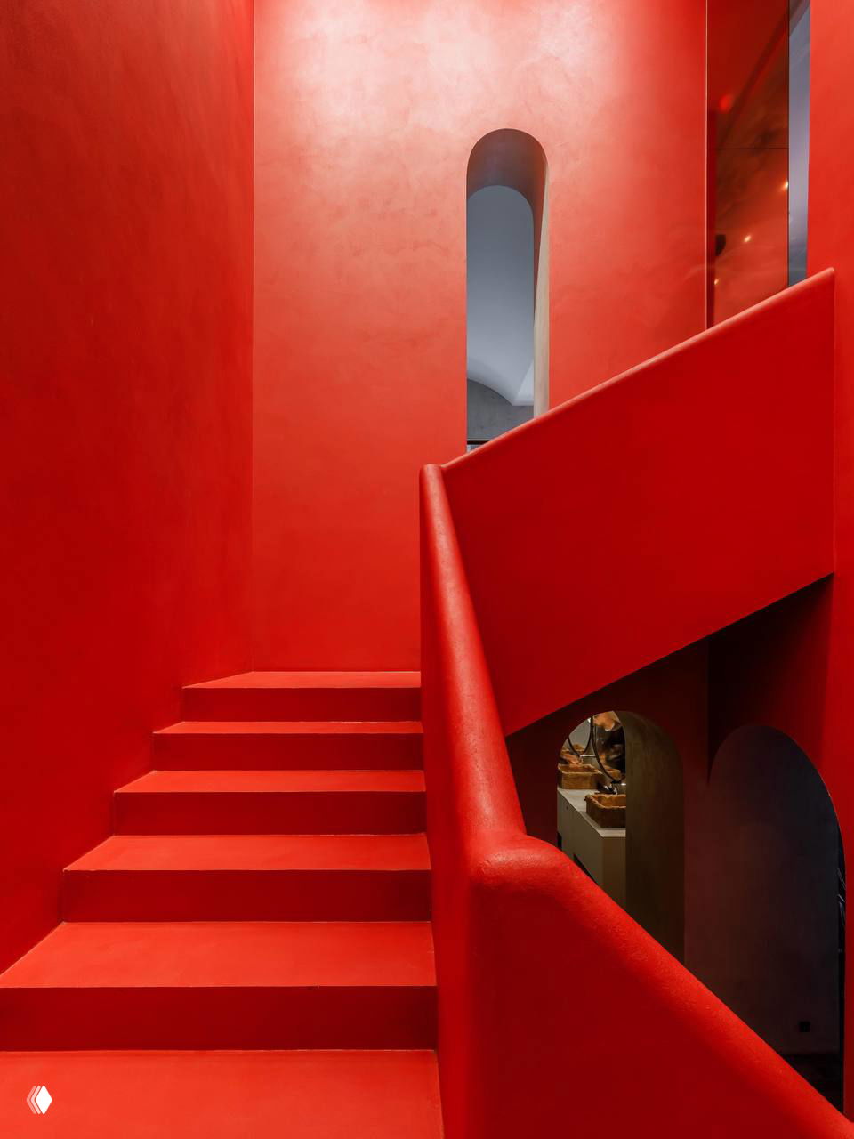 Интерьерный ракурс с деревянными креслами и абстрактным рисунком на стене; сервированные столы и нейтральная бетонная поверхность создают спокойный фон