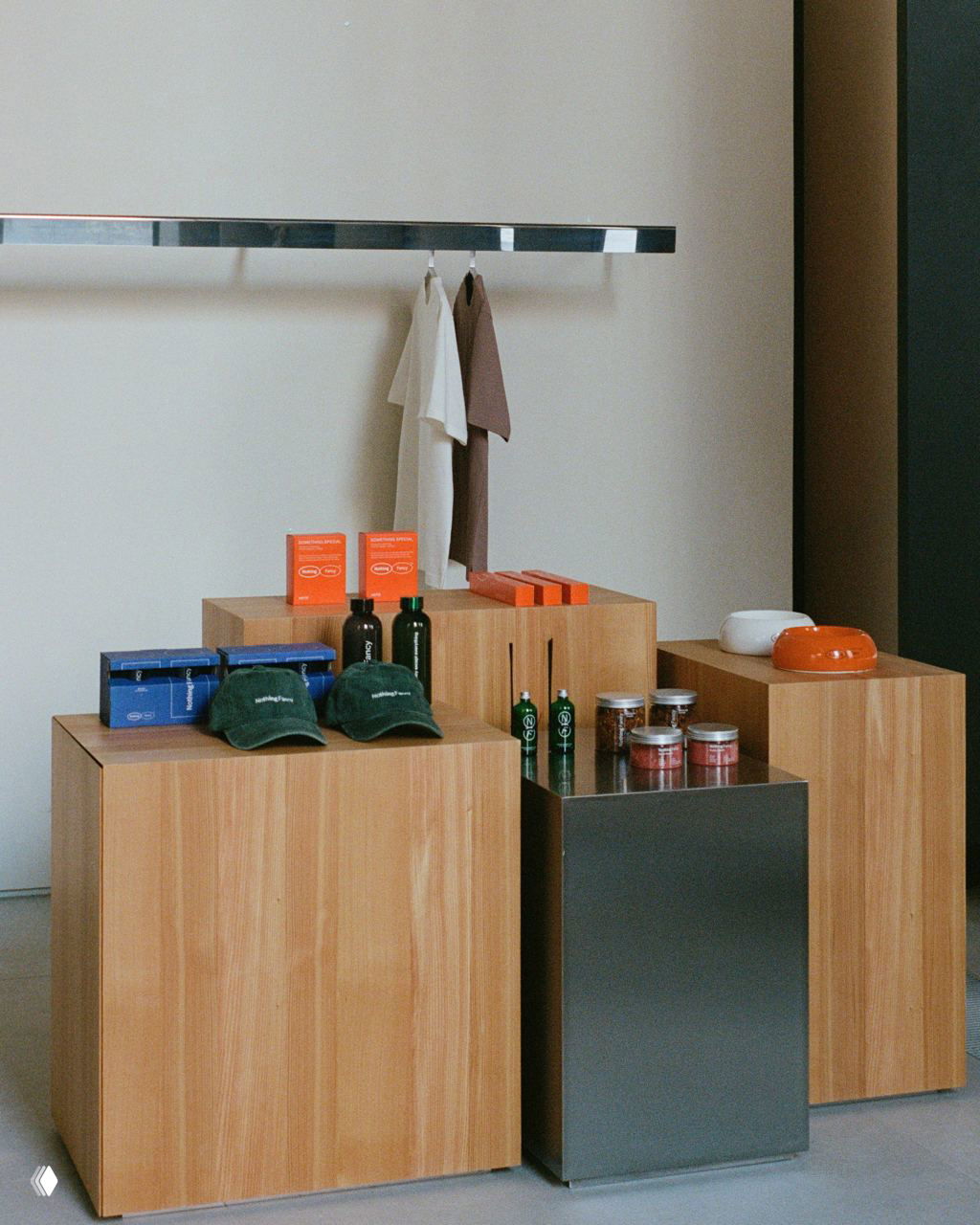 Деревянные кубы-витрины с мерчем, металлический подиум и минималистичная экспозиция товаров в зоне продажи внутри бистро Nothing Fancy.