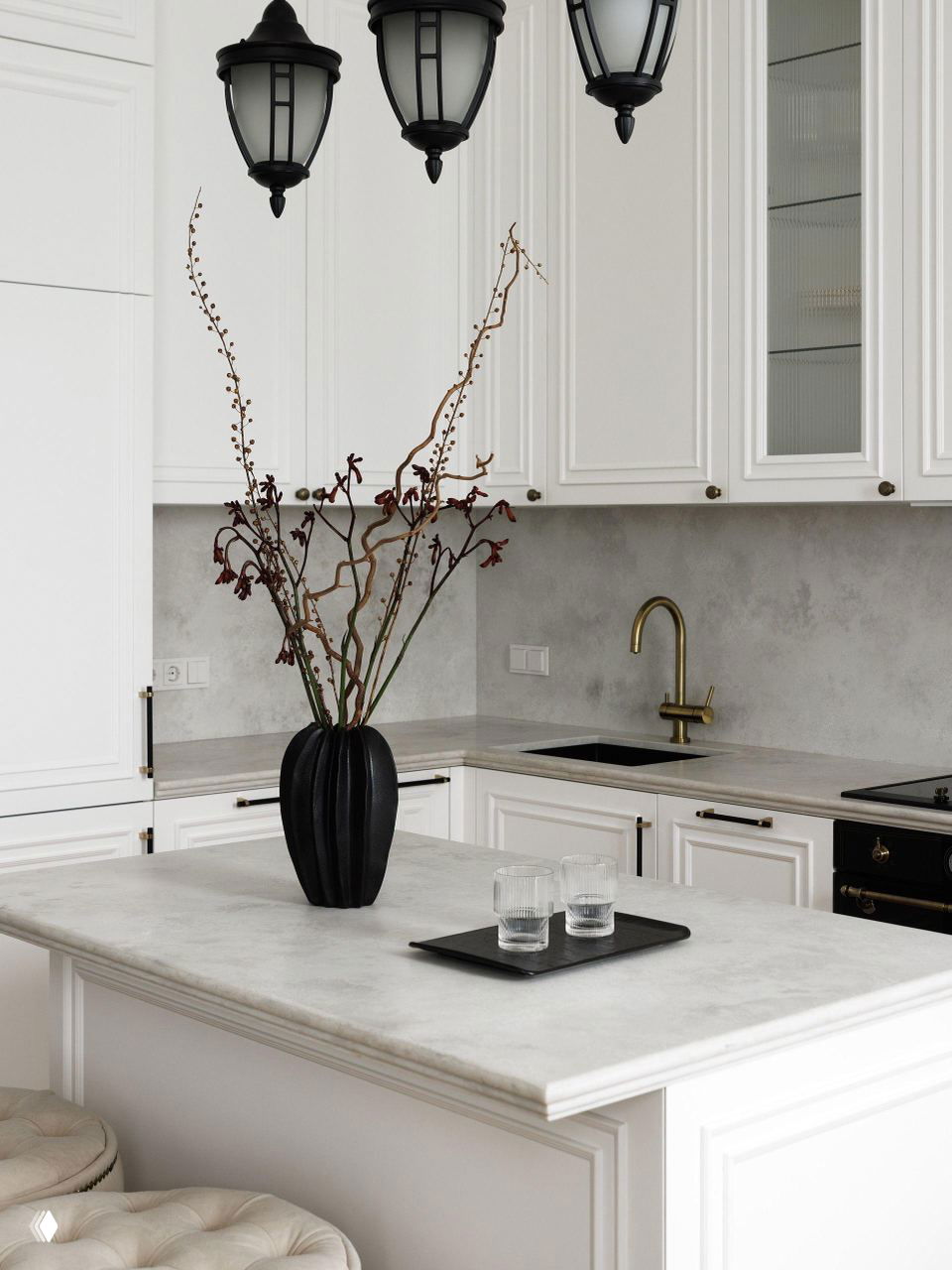 Кухонный остров и рабочая поверхность в белой классической кухне: мраморная столешница, золотой смеситель и декоративная ваза с ветвями на фоне фасадов в филёнке.
