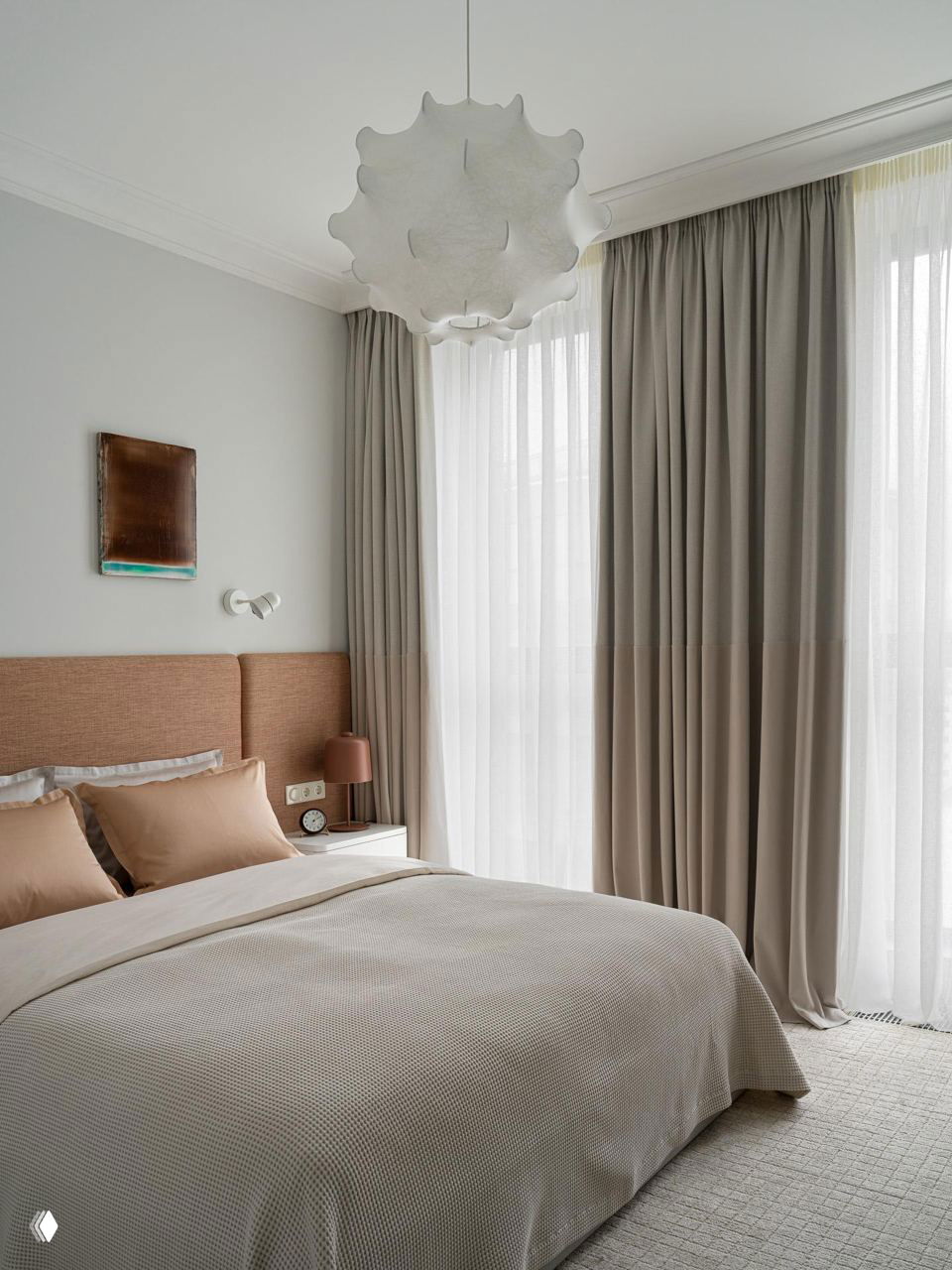 Спальня в нейтральной гамме: кровать с текстильным изголовьем, мягкие постельные ткани и большие шторы, создающие спокойный уют в 60 м²