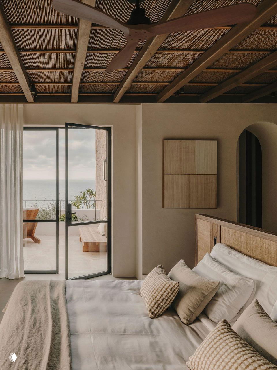 Спальня с двуспальной кроватью и выходом на террасу с видом на море — спокойные тона, натуральные текстуры и воздух Ибицы в интерьере.