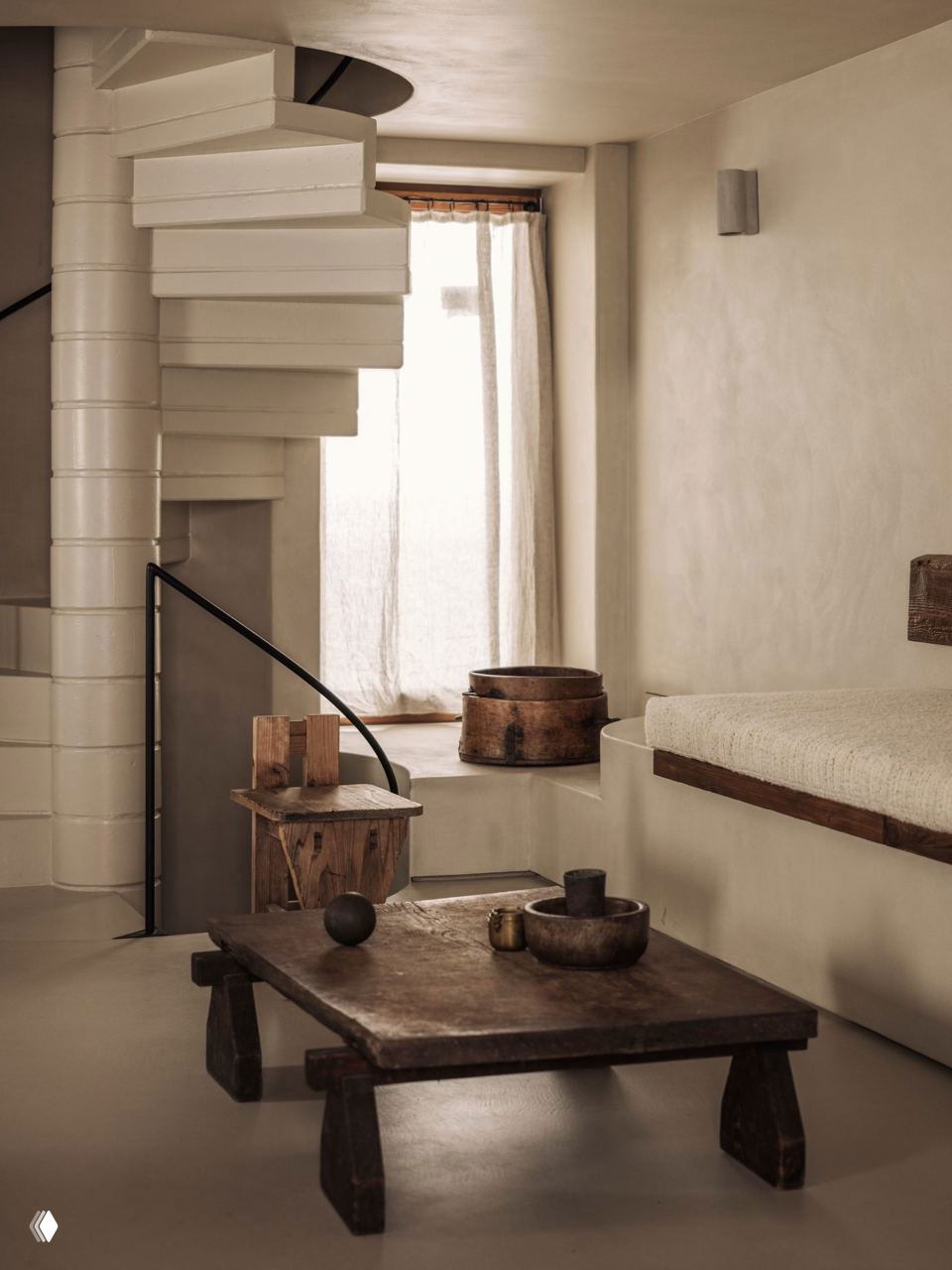 Белая винтовая лестница как центральный элемент интерьера связывает уровни шале; вокруг — нейтральные стены и минималистичная мебель из дерева.