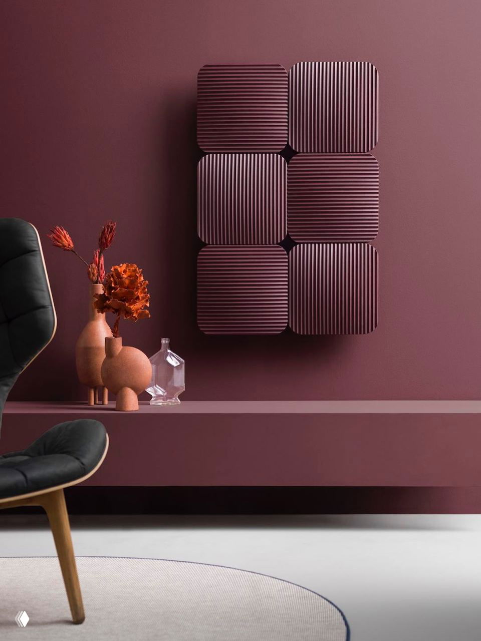 Шестиэлементная плиточная композиция радиатора Lana винного цвета на однотонной тёмно-сиреневой стене в декорированной гостиной зоне с вазами.