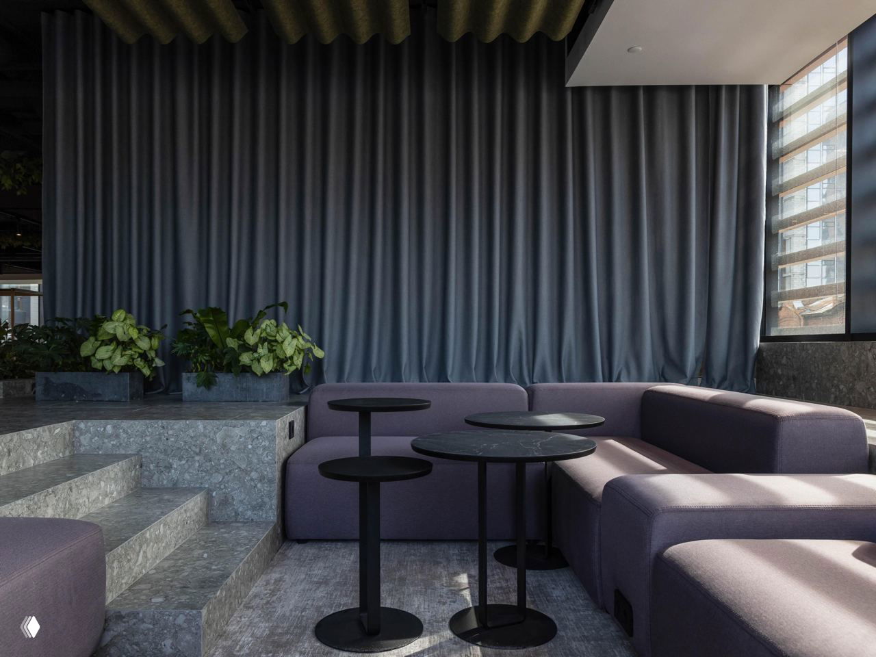 Низкая мягкая мебель в лиловых тонах, ступенчатая зона с декоративными растениями и плотными шторами — спокойная рекреационная зона внутри офиса.