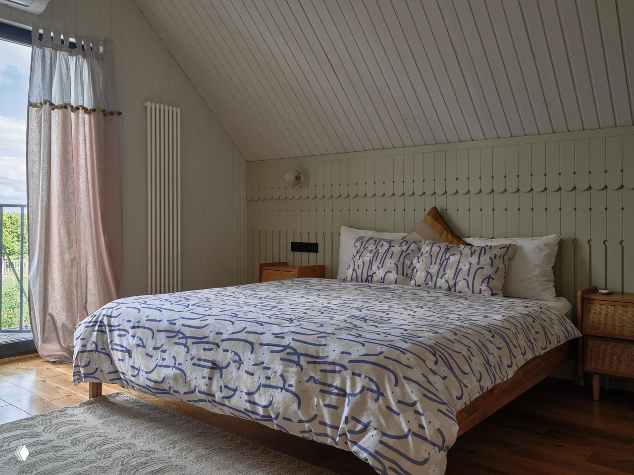 Ещё одна спальня на мансардном уровне: светлые стены, деревянная кровать и аккуратная текстильная отделка создают атмосферу загородного уюта.