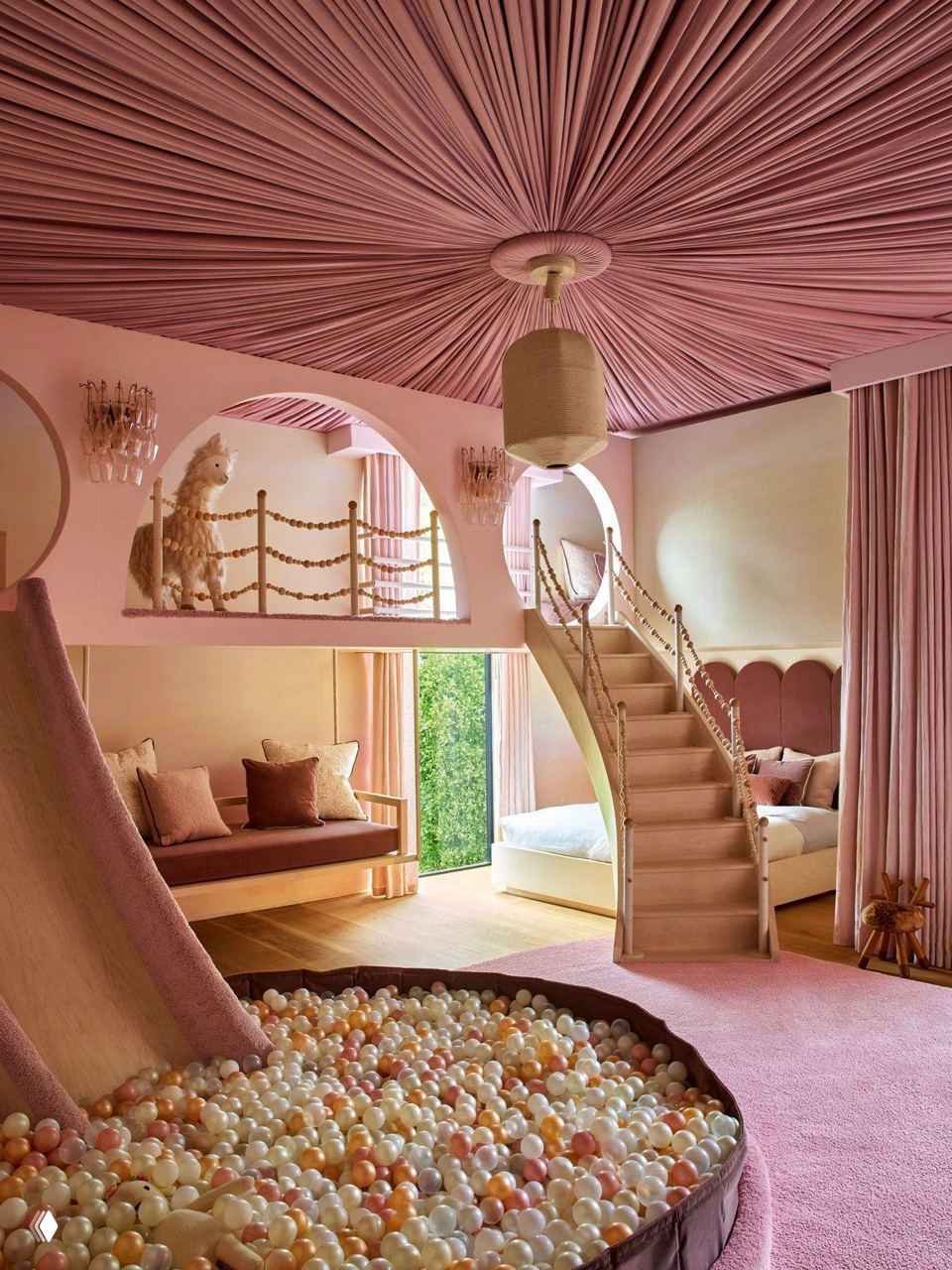 Розовая игровая комната с мягким балконом, лестницей, небольшой горкой и большим сухим бассейном с пастельными шариками для интерактивной игровой зоны и уюта.