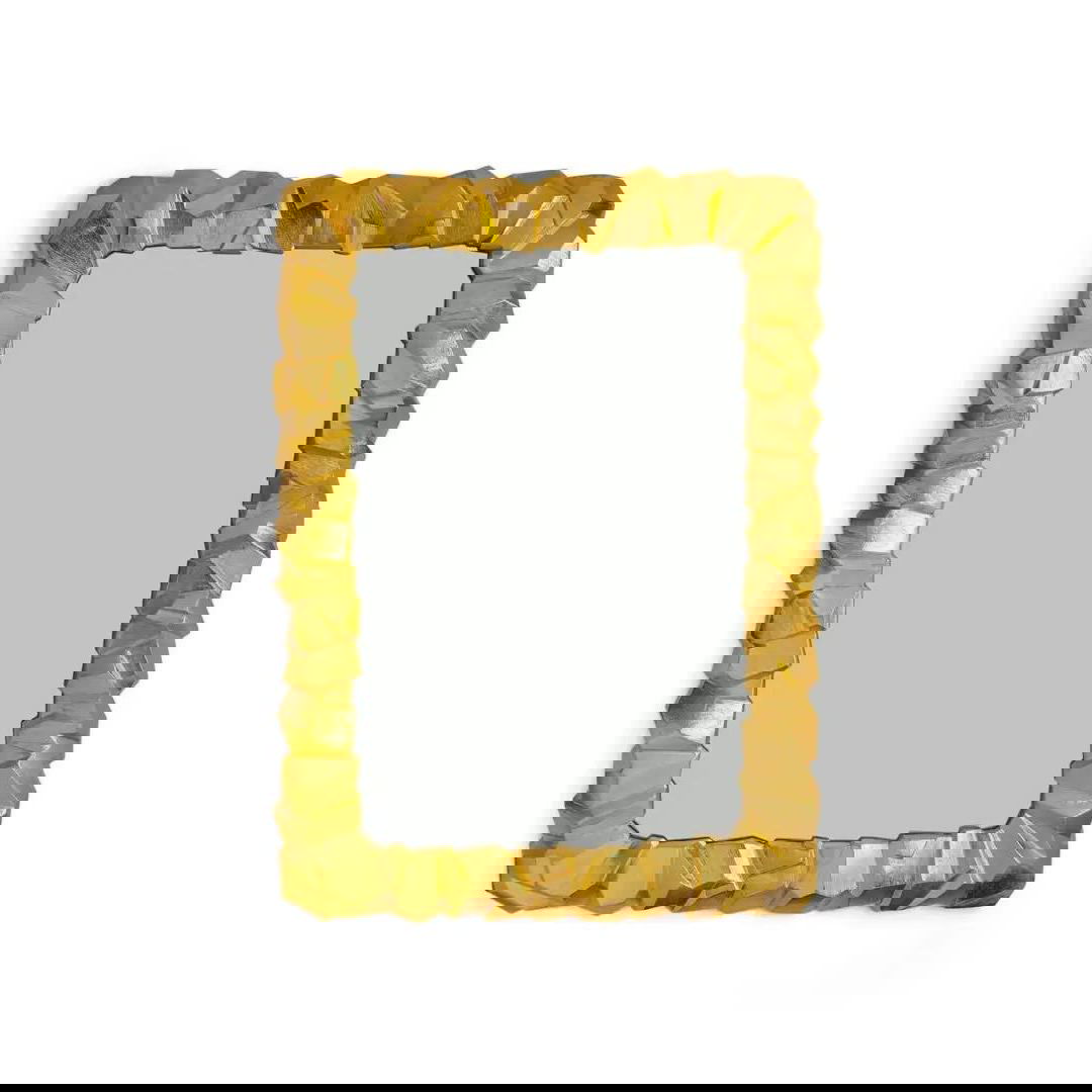 Золотая декоративная рама зеркала с неровной текстурой на белом фоне — роскошная идея подарка для любителей гламура и театрального интерьера.