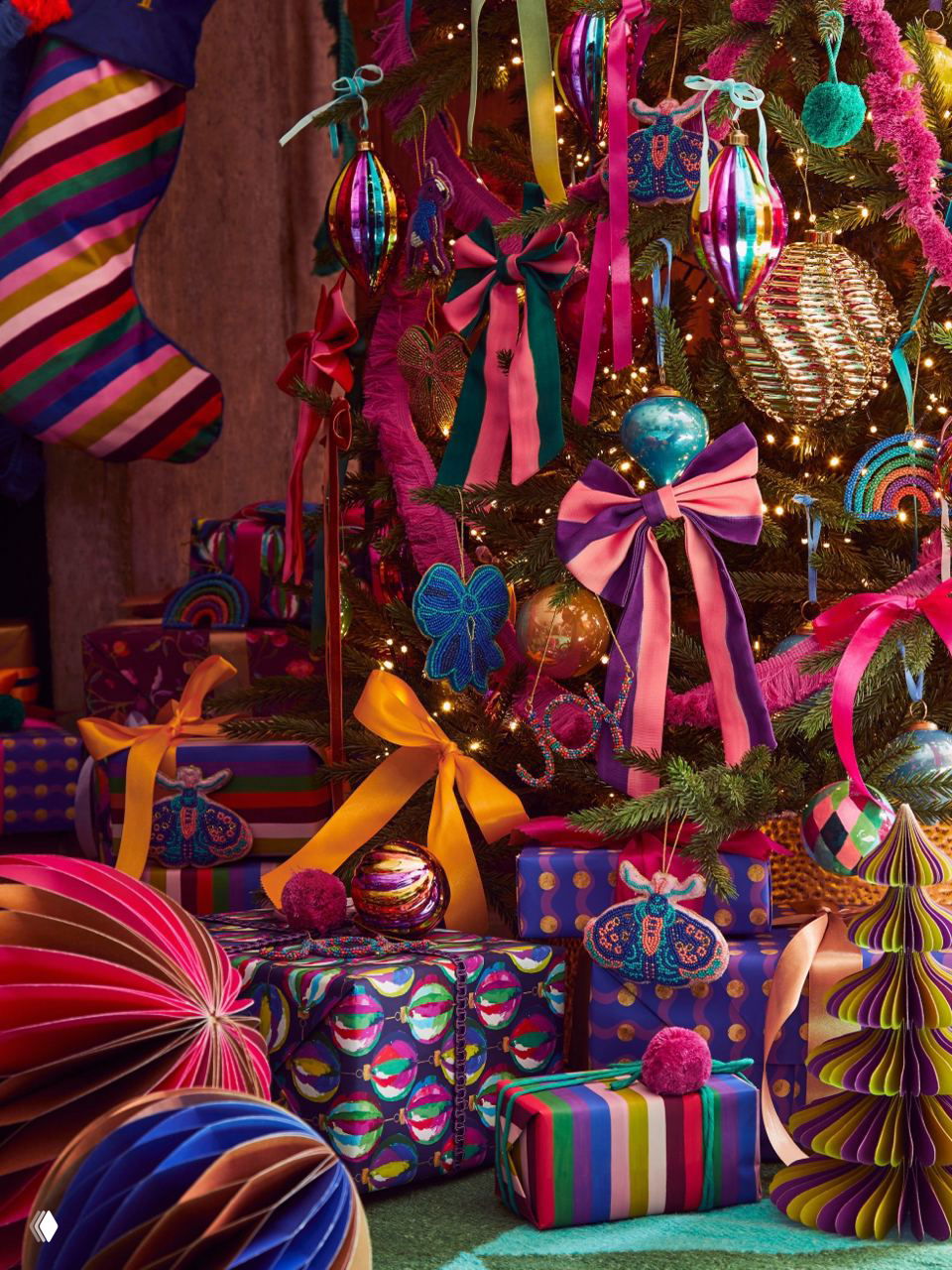 Ярко украшенная новогодняя елка в насыщенных цветах: крупные банты, блестящие игрушки, гирлянды и множество красочных подарков у основания.