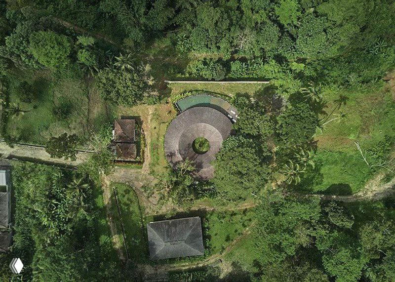 Аэровид сверху: кольцевая форма здания и зелёный внутренний двор в окружении тропической растительности южнее Убуда.