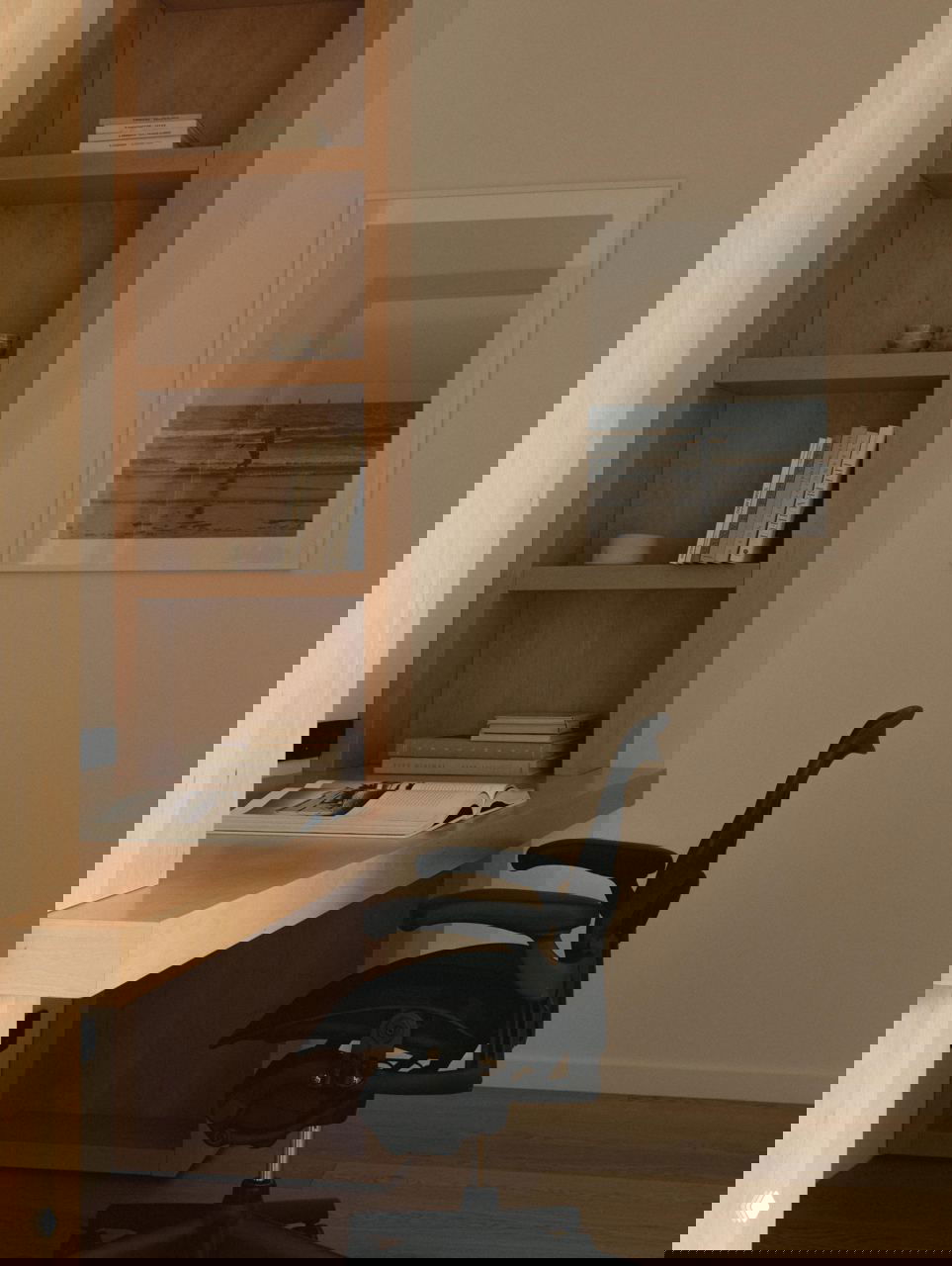 Рабочая зона с встроенным деревянным столом и эргономичным креслом, организованные полки и плакат на стене — дом с местом для удалённой работы.