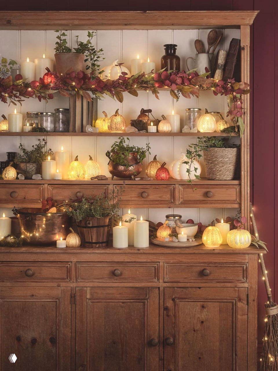 Стеллаж с подсвечниками, свечами и мини‑тыквами в тёплом освещении — идея мягкого, уютного осеннего украшения полок и каминной зоны.