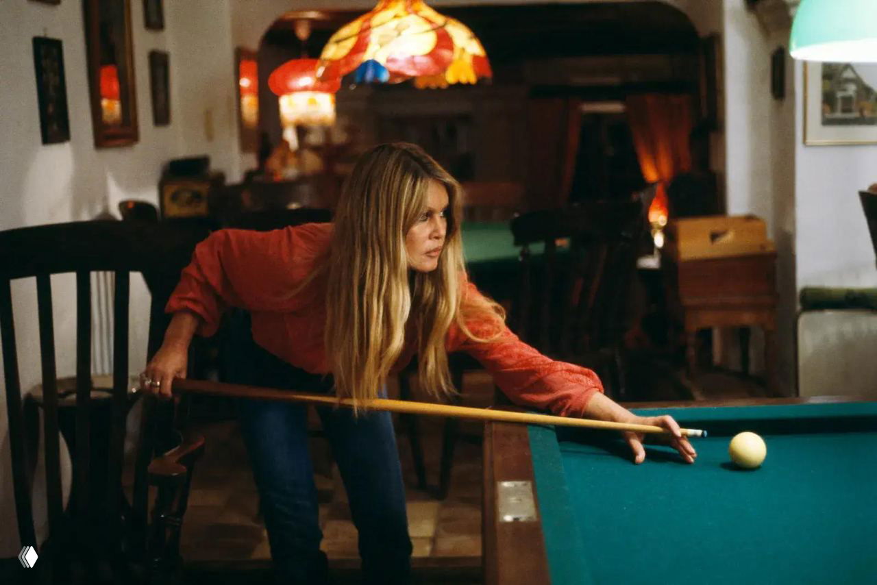 Архивный кадр: женщина делает удар кия по бильярдному шару в домашнем бильярдном зале — домашняя атмосфера и личные вещи.