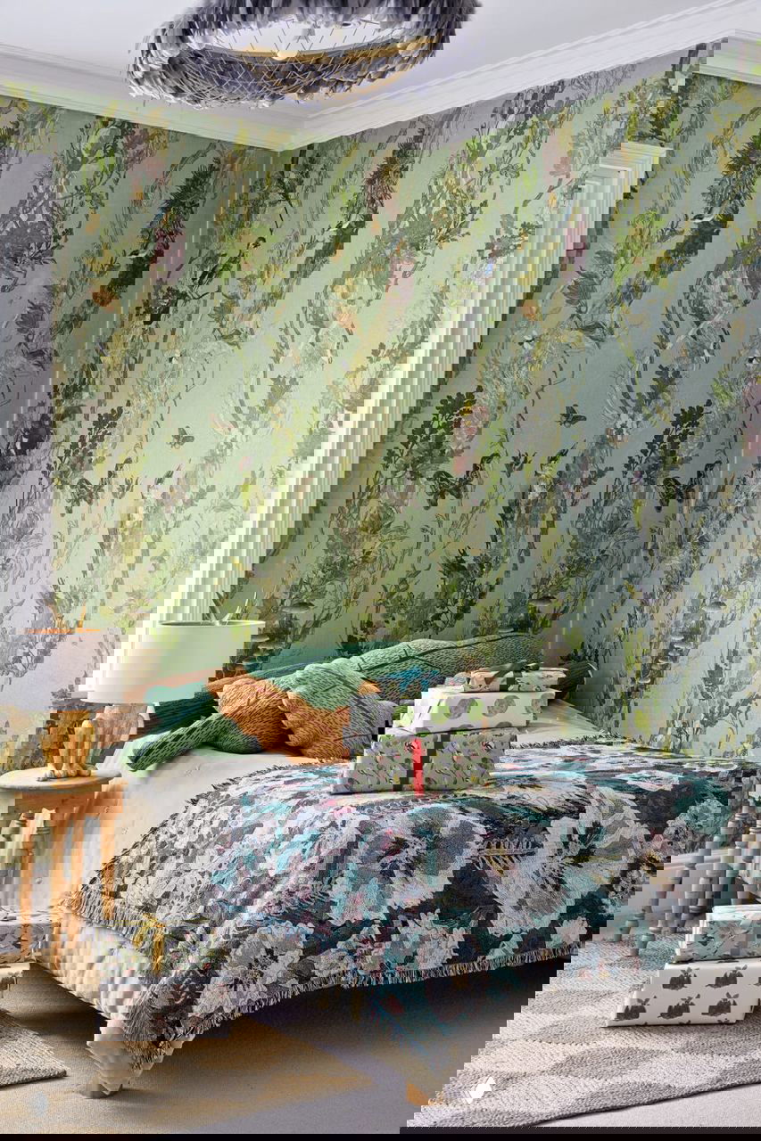 Спальня с цветочно-растительными обоями и декоративным покрывалом, подарки у изножья кровати — спокойный праздничный уголок в доме дизайнера.