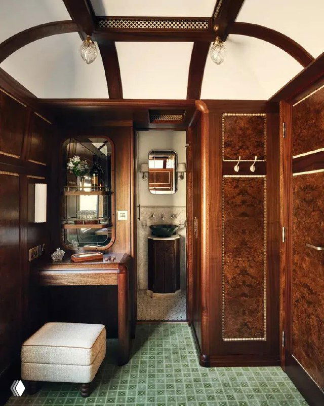 Туалетный столик и небольшая ванная зона в сьюте поезда с панелями из красного дерева и зеркалом над раковиной, детальная отделка маркетри