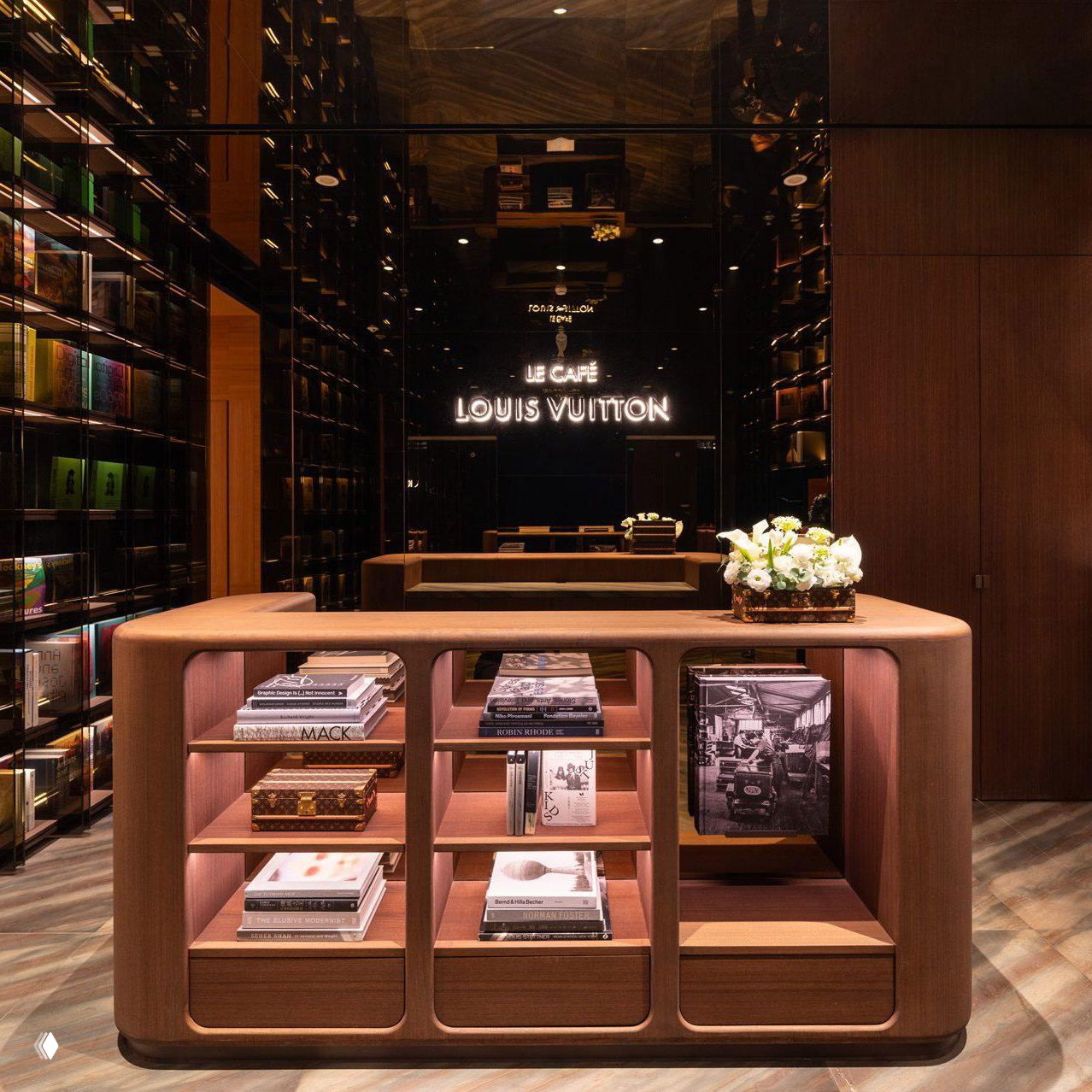 Книжные полки и библиотечная зона в интерьере бутика Louis Vuitton: тёплая подсветка, коллекция книг и дизайнерская меблировка.