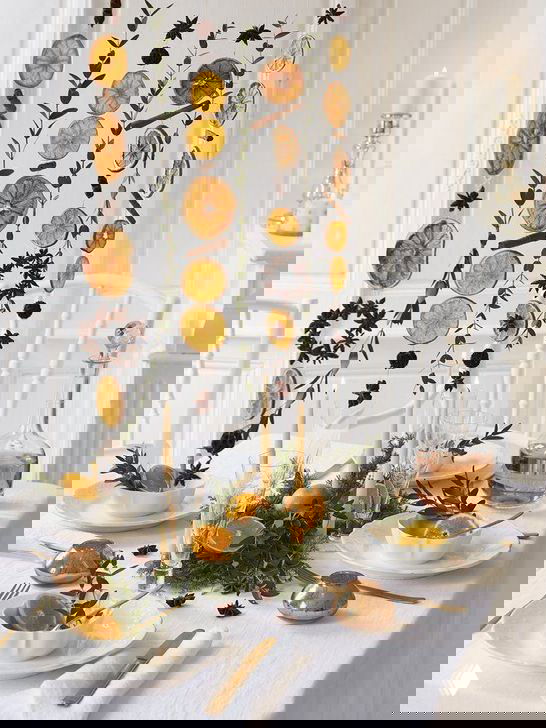 Белая столовая с подвесными сухофруктами и лёгкой зимней сервировкой, идеи для оформления окна и стены в небольшом помещении