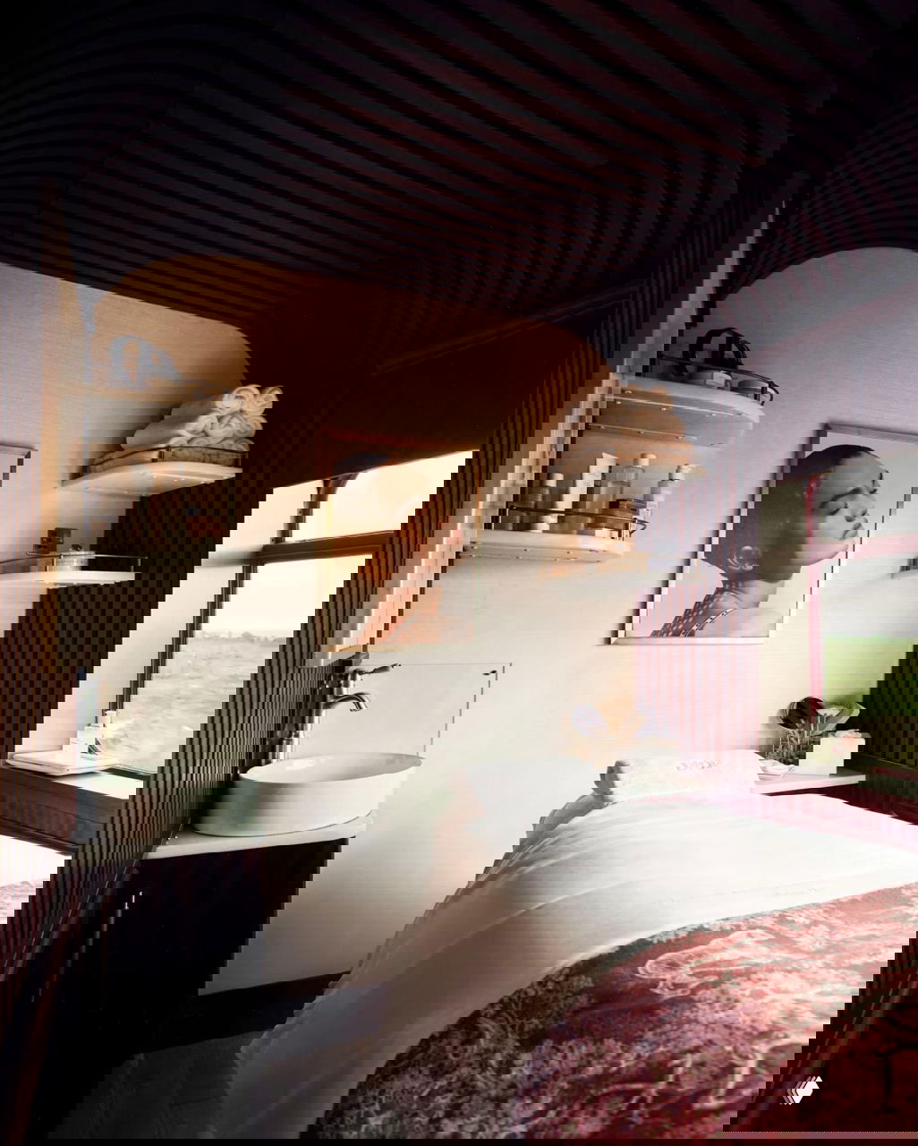 Спа-пространство Dior в купе поезда: массажная кушетка, аккуратно сложенные полотенца и косметические средства на полках рядом с окном