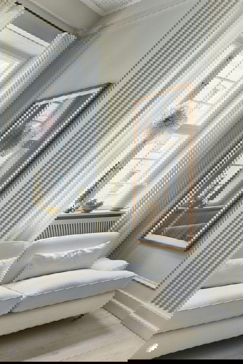 Близкий план барочной люстры, украшенной гирляндой из эвкалипта, стеклянными шарами и кристаллами — центральный акцент праздничного декора.