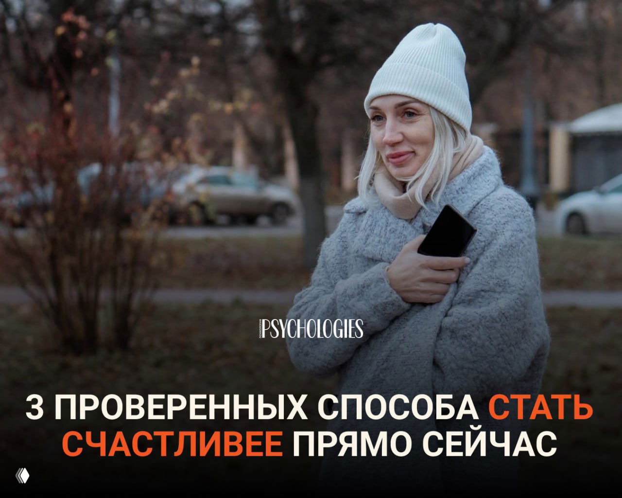 Женщина в шапке и пальто держит телефон на прогулке в парке; иллюстрация к советам по снижению тревоги и поднятию настроения.