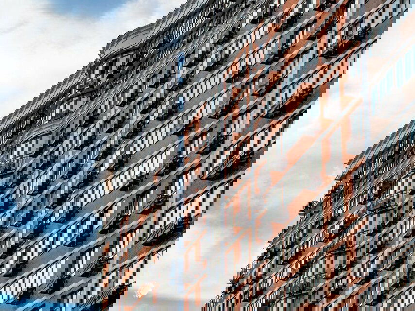 Крупный план архитектурного решения фасада: вертикальные панорамные окна, декоративные элементы и балконы жилого дома в «Самолете».