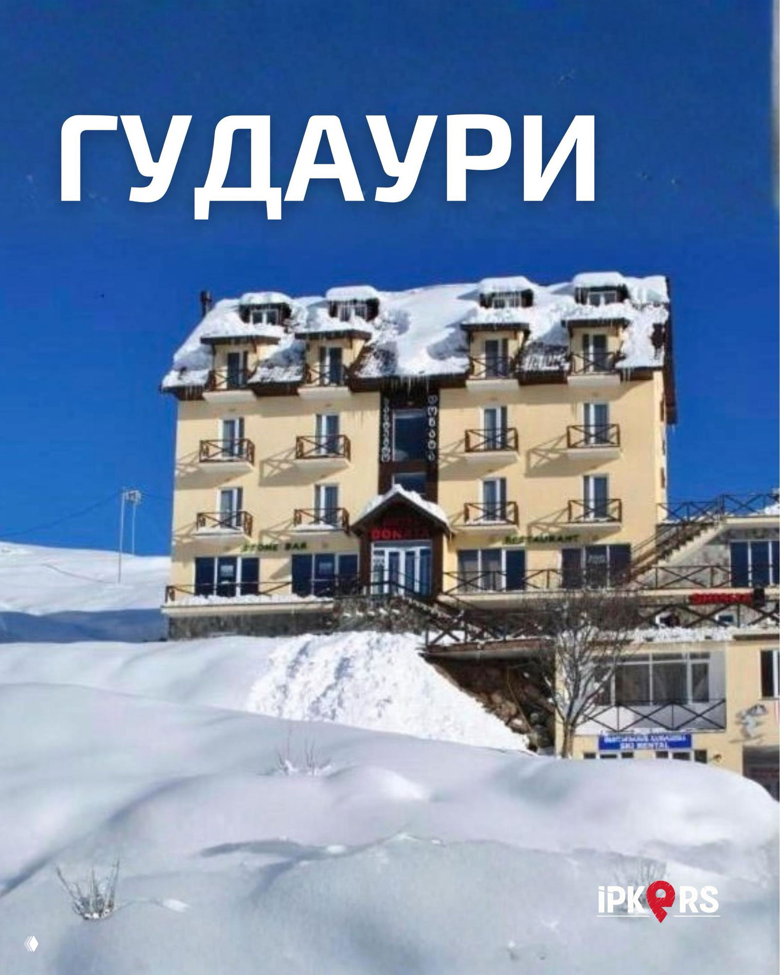 Фасад горного отеля в Гудаури зимой, здание у заснеженного склона рядом с подъемником, вид корпуса и бренд IPKERS в углу объявления