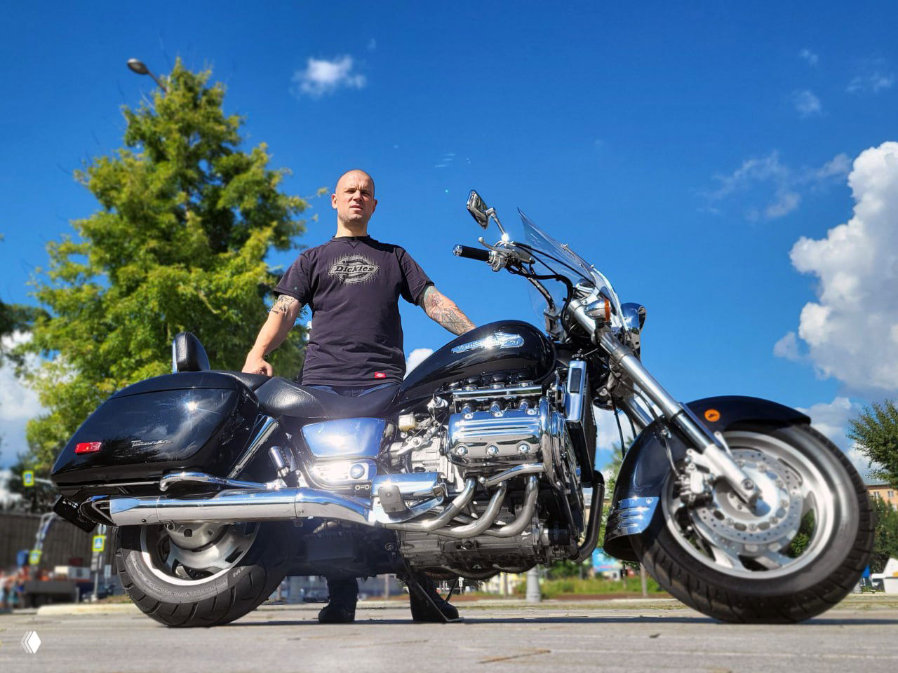 Николай стоит рядом с мотоциклом Honda Valkyrie 1500 на открытой площадке; в кадре видна крупным планом хромированная шестицилиндровая оппозитная силовая установка и детали круизера.