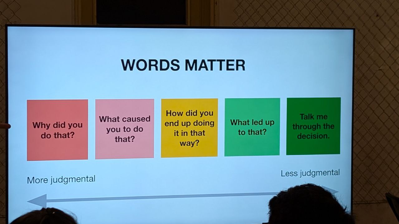 Фотография слайда презентации: заголовок 'WORDS MATTER' и пять цветных блоков с вопросами, иллюстрирующих переход формулировок от более осуждающих к менее осуждающим.